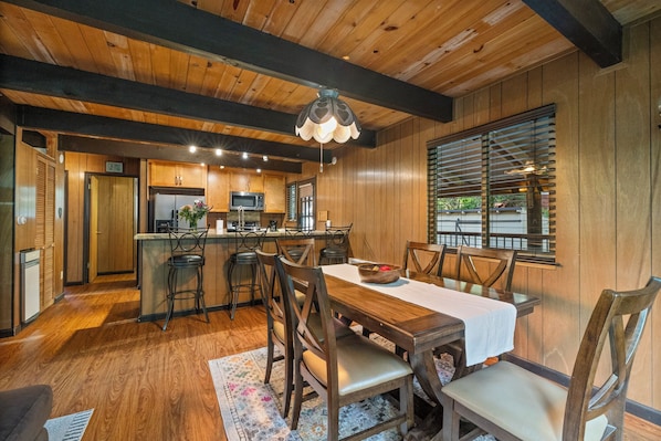 A wooden interior with a kitchen, dining area, and a bar.