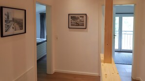 A hallway with framed pictures on the walls, a wooden ceiling, and a door leading to another room. - Holiday Home 'Sonnenweide, 85qm' with Private Terrace, Shared Garden and Wi-Fi (Salem)