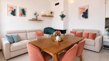 Un salon moderne avec une table à manger en bois, deux canapés et une cheminée.