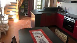 Una cocina moderna con armarios rojos, una encimera negra y un horno empotrado.