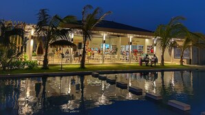 A resort with outdoor seating, palm trees, and a pool. - Beachfront Condo | Caracol Beach, Punta Chame | Pools & Ocean Views (Chame)