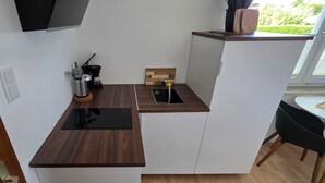 Coffee/tea maker, fridge, stovetop, cookware/dishes/utensils
