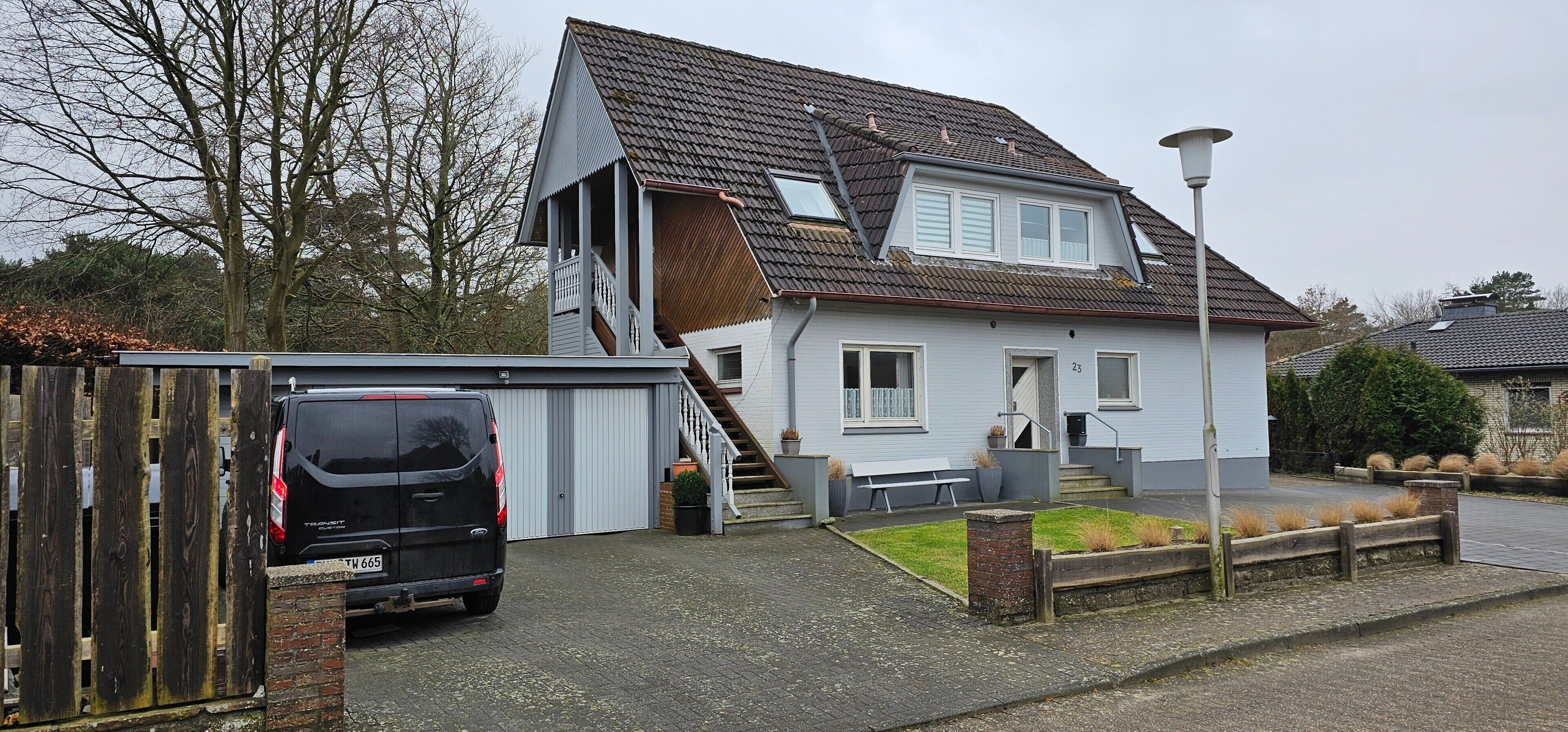 Et toetagers hus med garage, trappe og en lille forhave.