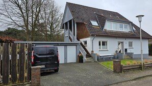 A two-story house with a garage, a staircase, and a small front yard.