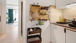 A modern kitchen with a pegboard holding utensils, a sink, and a stove.