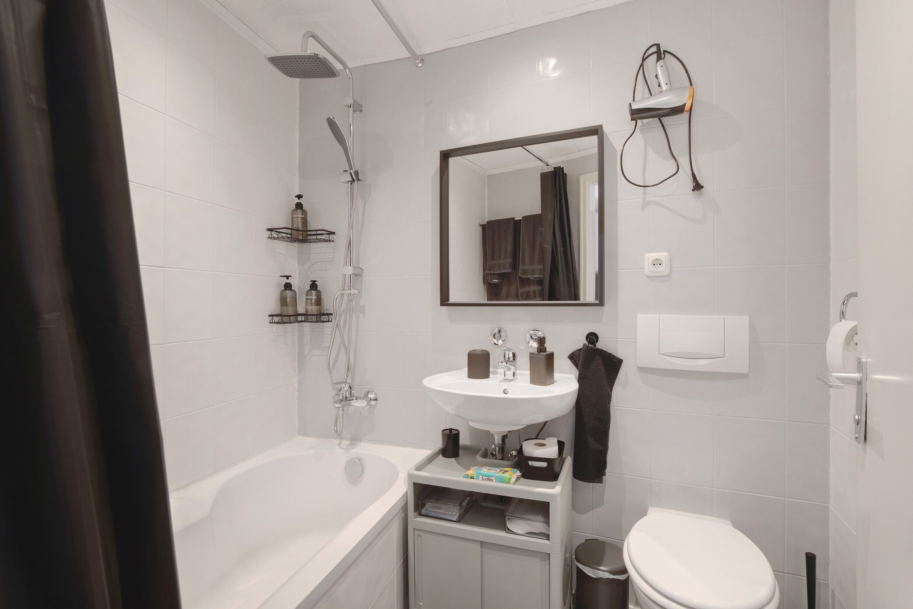 Een moderne badkamer met een bad, een wastafel, een spiegel en een douche.