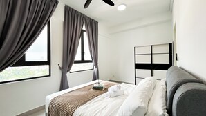 A hotel room with a bed, a bedside table, a window with curtains, and a view of the city. - 168 Park Selayang by Manhattan Group (Batu Caves)