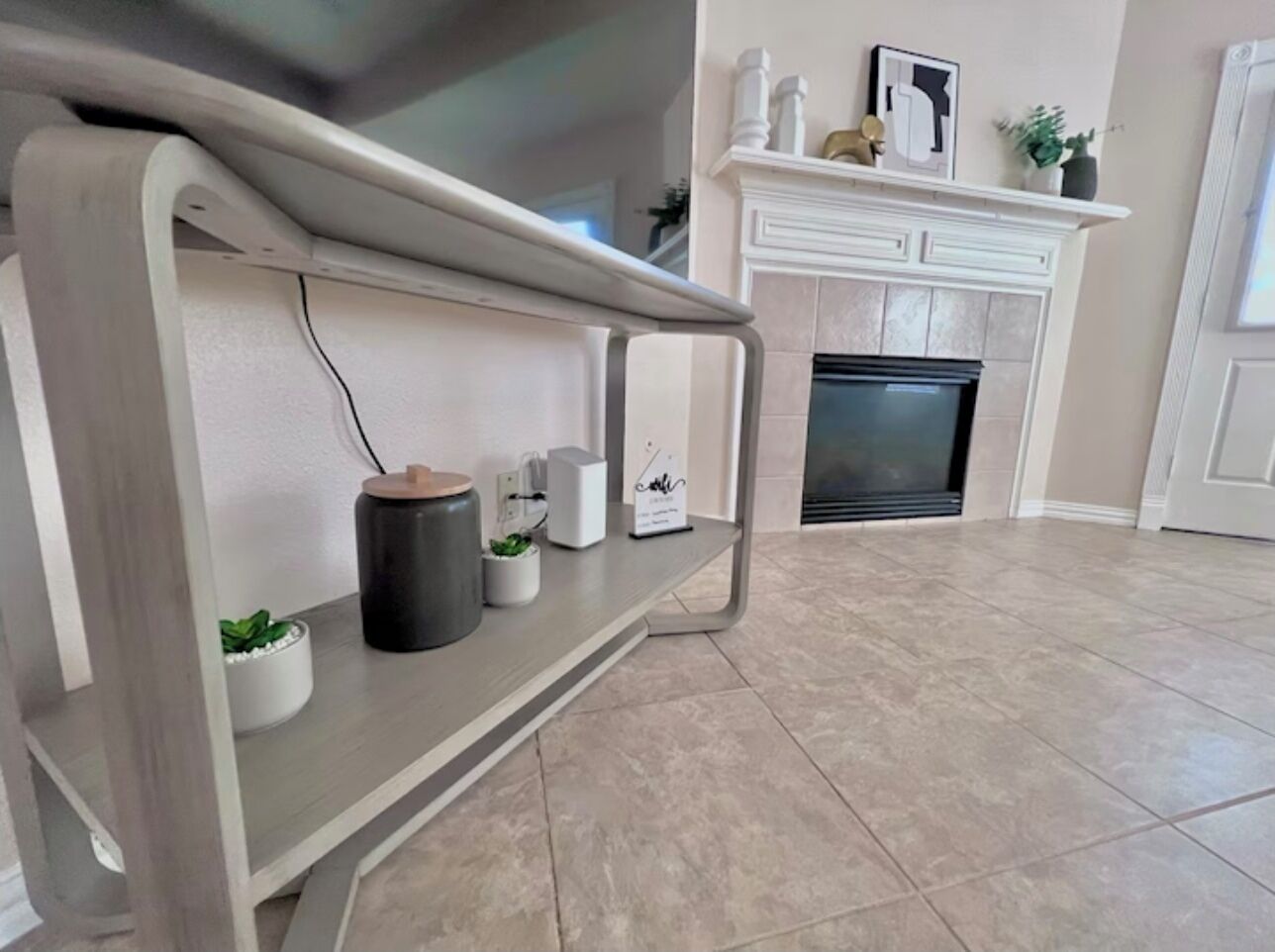 A modern living room with a built-in bench, a fireplace, and a tiled floor.
