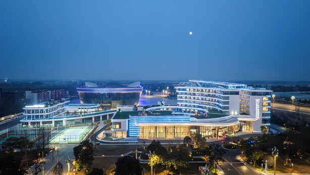 Un hotel moderno con varias construcciones, un patio central y vistas del entorno.