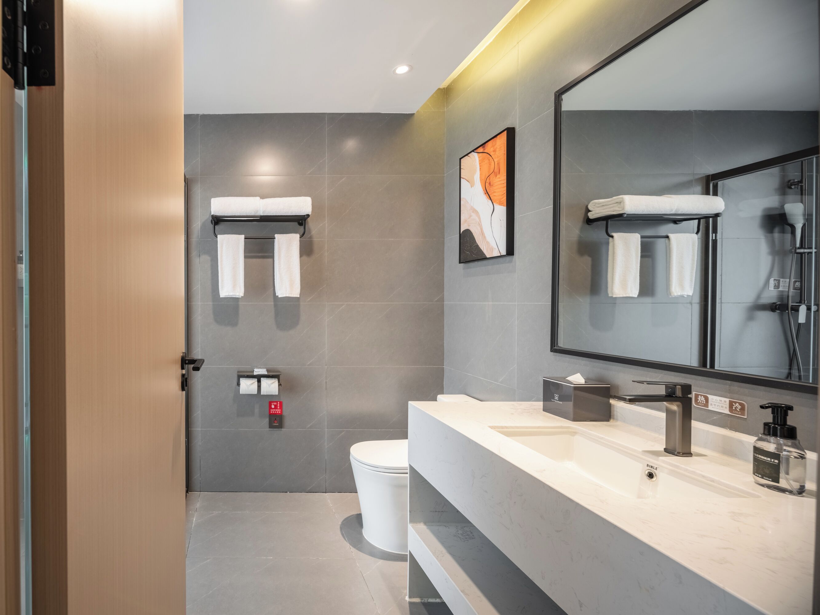 A modern bathroom with a toilet, sink, and towel rack.