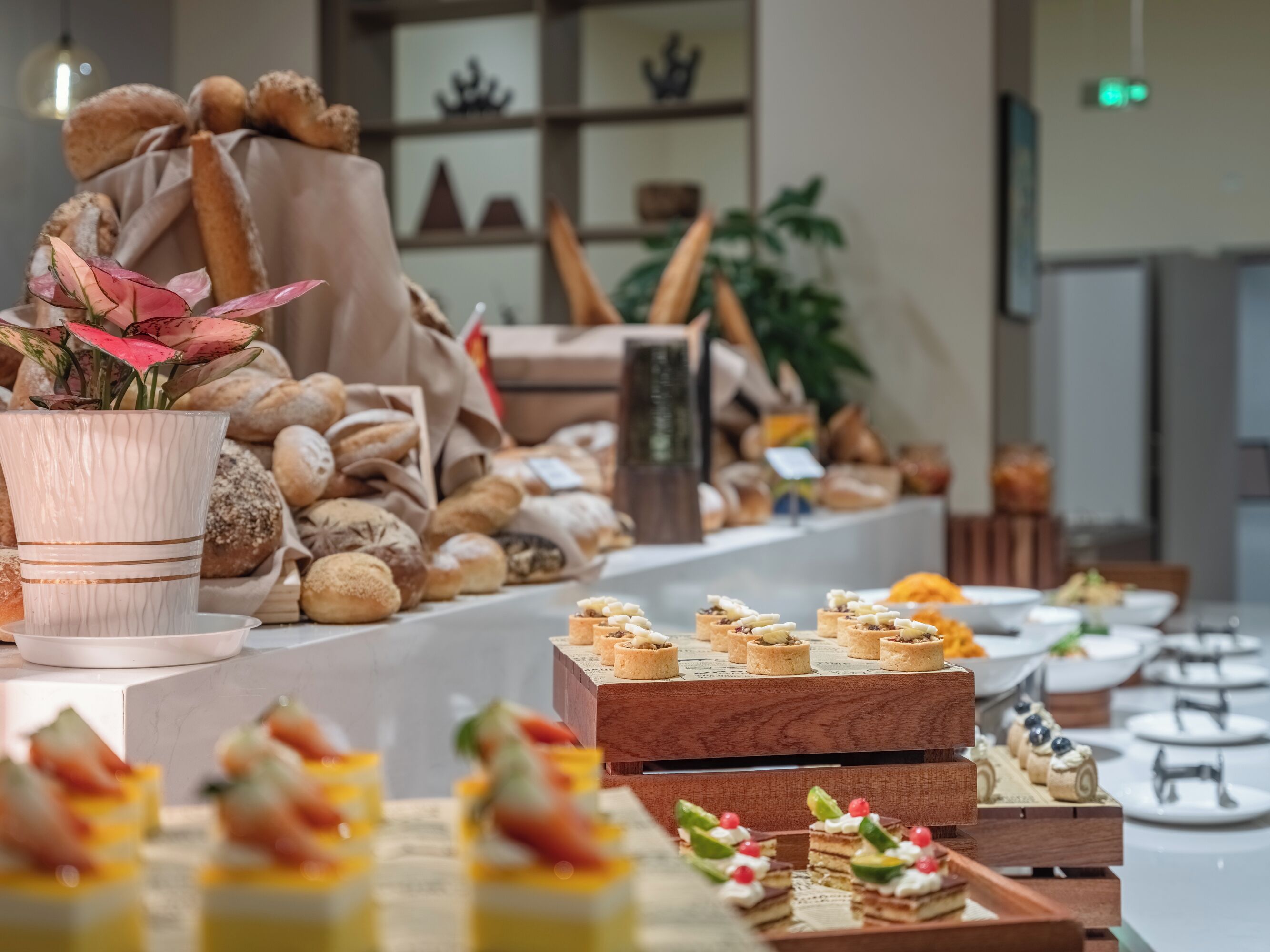 A buffet table with various pastries and desserts, including small cakes and fruit-topped items.