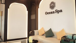 Un hall de hotel con un sofá, almohadas, una mesa y un cartel que dice OceanSpa.