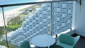 Un balcón con vista a la playa y edificios de hotel.