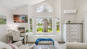 A cozy living room with a large window, a desk, and a comfortable seating area. - Lake Front Home, Newly Remodeled, Hot Tub, Game Room, Views! (Pagosa Springs)
