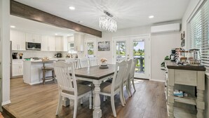 A spacious kitchen with white cabinetry, a wooden dining table, and a chandelier. - Lake Front Home, Newly Remodeled, Hot Tub, Game Room, Views! (Pagosa Springs)