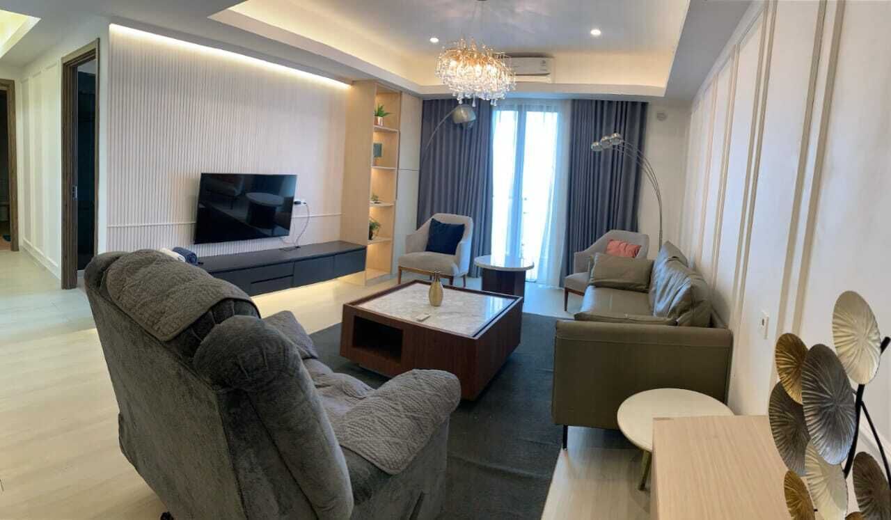 Una sala de estar moderna con un conjunto de sofá, una mesa de centro y un televisor.