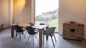 Ein Essbereich mit einem Holztisch, Stühlen, einer Obstschale und einem Holzschrank.