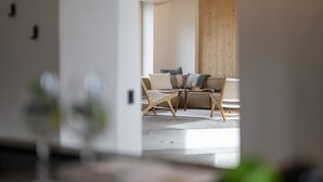 Ein modernes Wohnzimmer mit einer Couch, zwei Sesseln und einem Couchtisch.