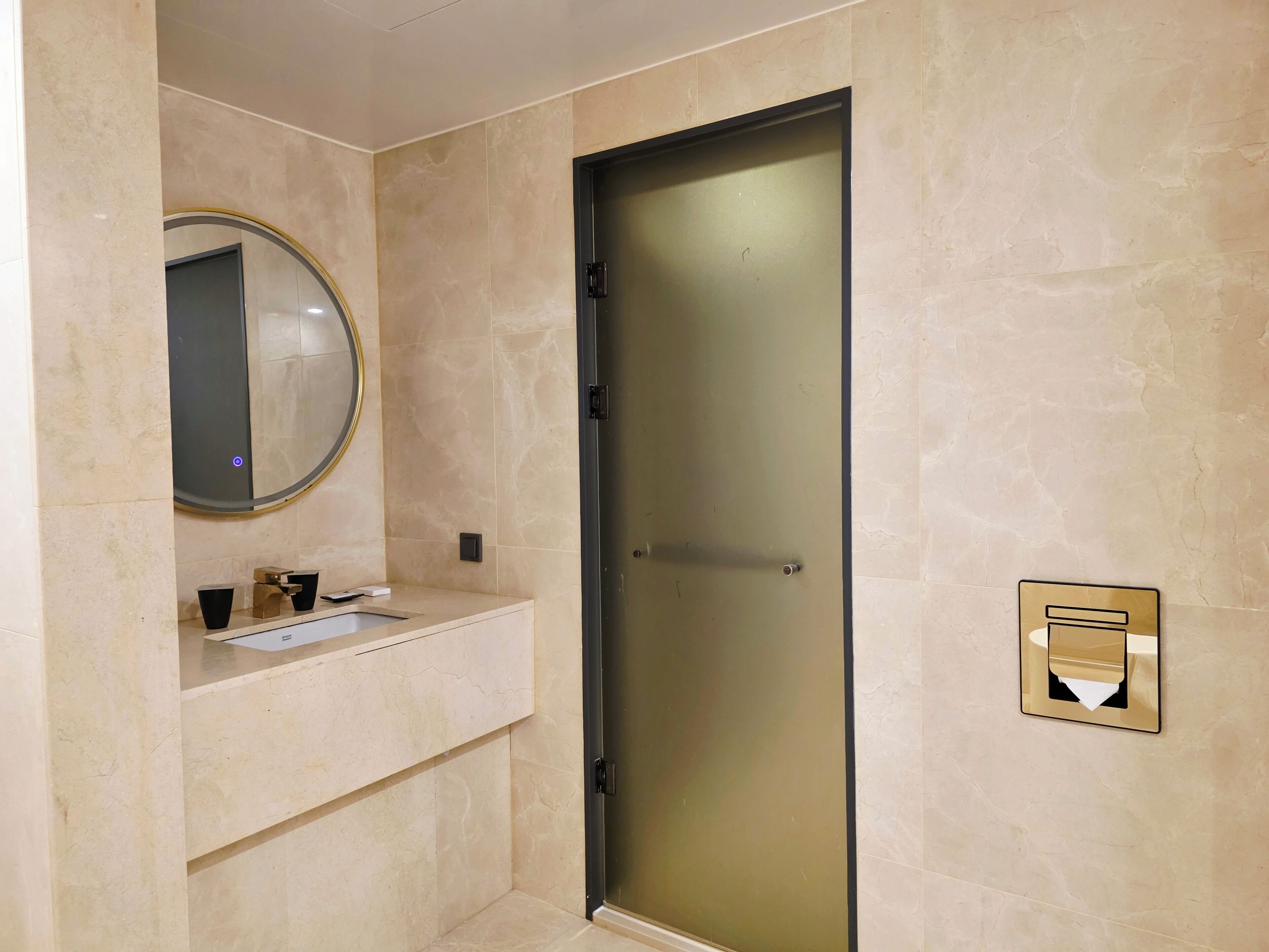 Un baño con lavabo, espejo y puerta.