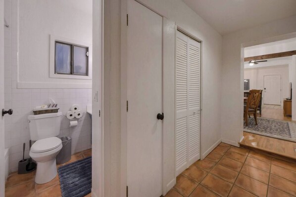 A compact bathroom with a toilet, sink, and window.