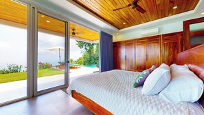 Une chambre moderne avec un grand lit, un plafond en bois et une vue sur une piscine et un jardin.