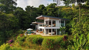 A modern two-story house with a pool, surrounded by lush greenery and tropical plants. - Private Villa Oro Verde, ocean view, luxury (Uvita)