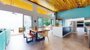 A modern kitchen with a central island, built-in appliances, and large windows. - Private Villa Oro Verde, ocean view, luxury (Uvita)