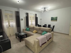 A living room with a sofa, a coffee table, and a TV stand.