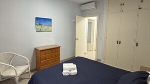 Ein Schlafzimmer mit Bett, Schminktisch, Stuhl und Kleiderschrank.