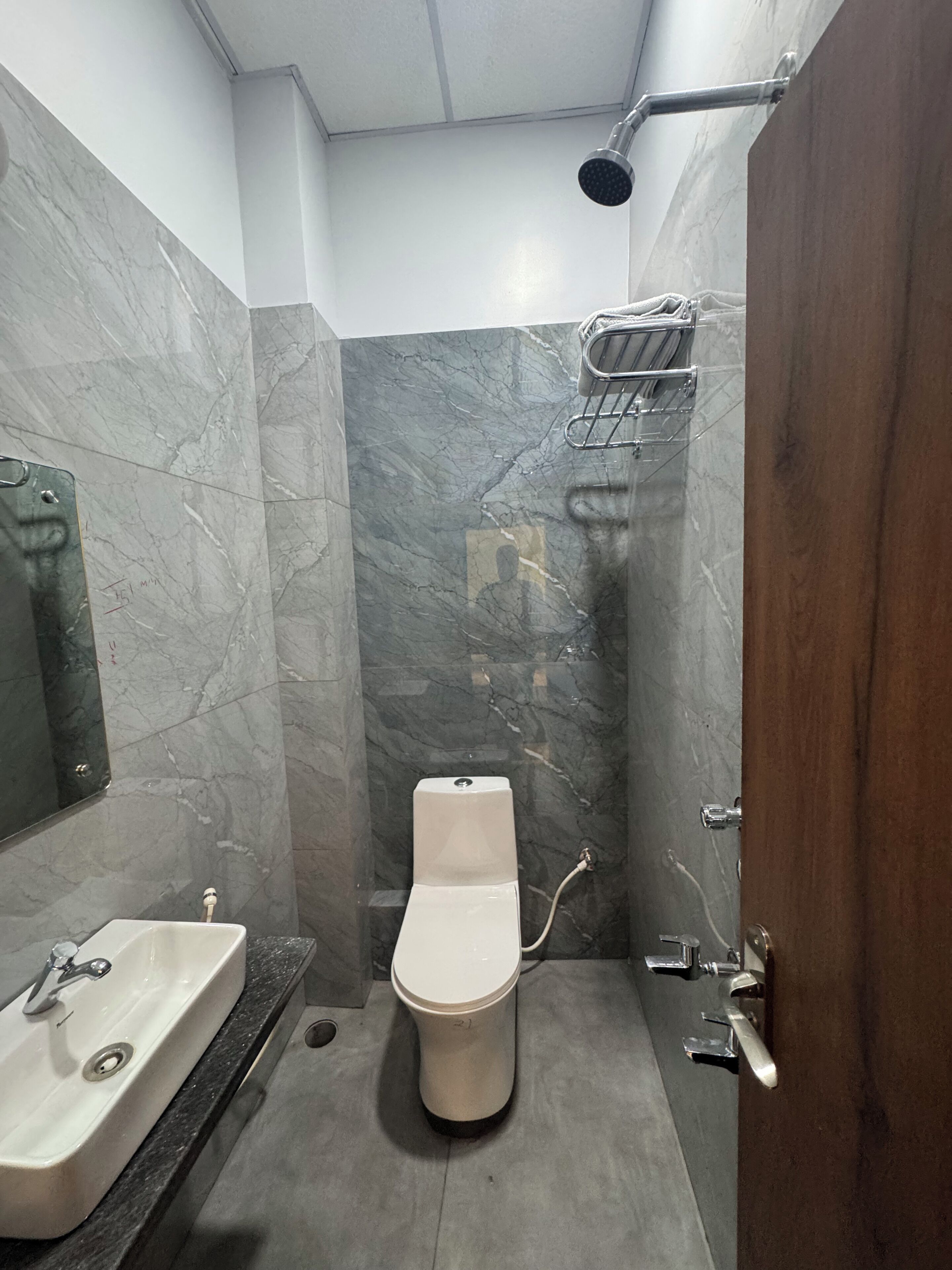 A bathroom with a toilet, sink, and shower.