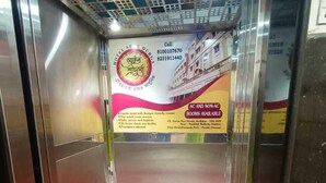 Un ascenseur avec un tapis rouge et une enseigne publicitaire pour un hôtel.
