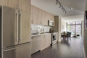 Enjoy meals in the kitchen with a dining area nearby, featuring a refrigerator, microwave, and natural light.