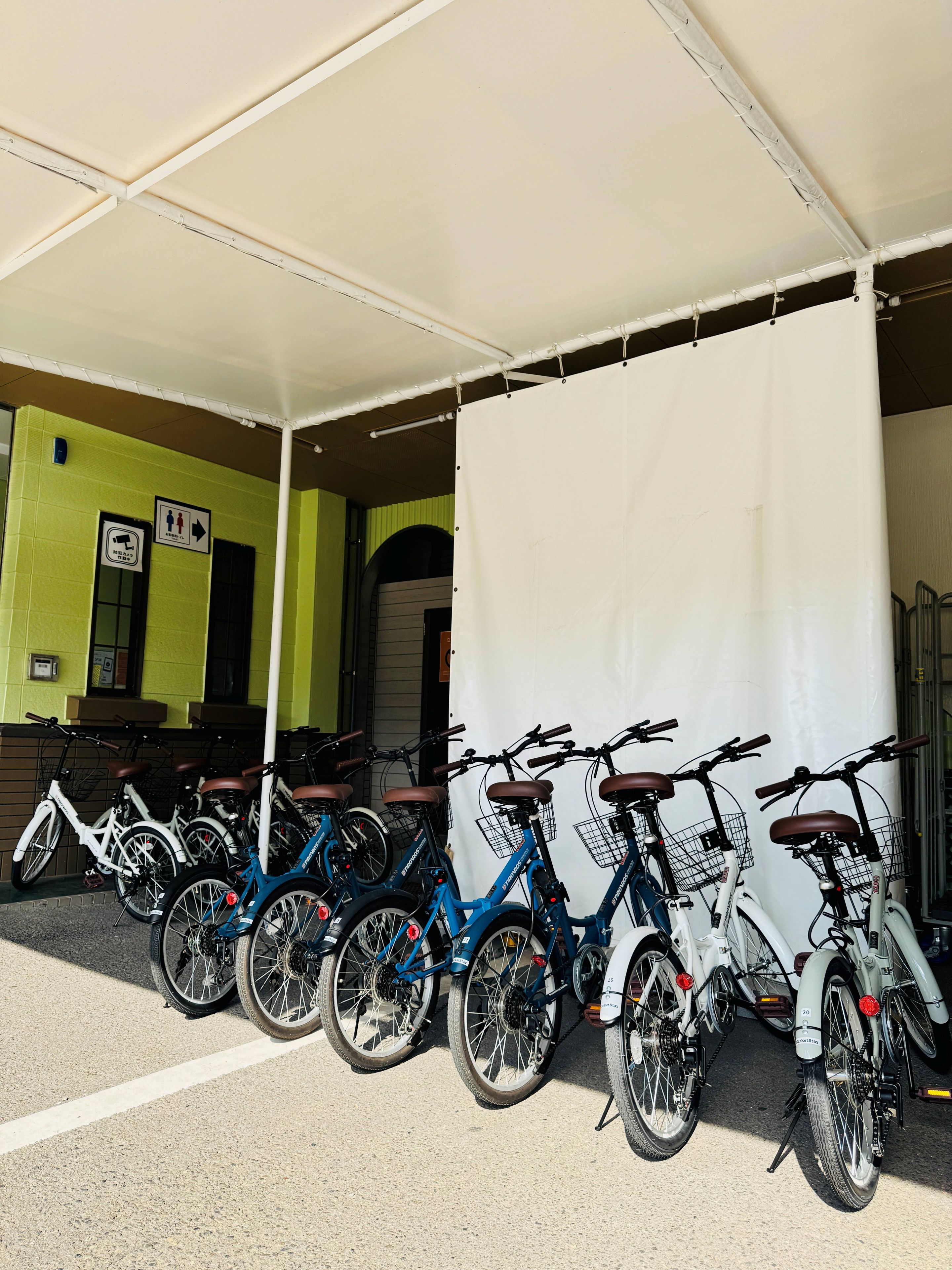 Un espace de stationnement pour vélos abrité, où sont garés plusieurs vélos.