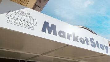 Un letrero con el texto 'MarketStay' y un gráfico de un puesto de mercado.