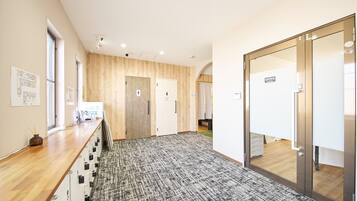 Un couloir moderne avec des murs lambrissés en bois, une moquette à motifs et un comptoir d’accueil avec une enseigne.