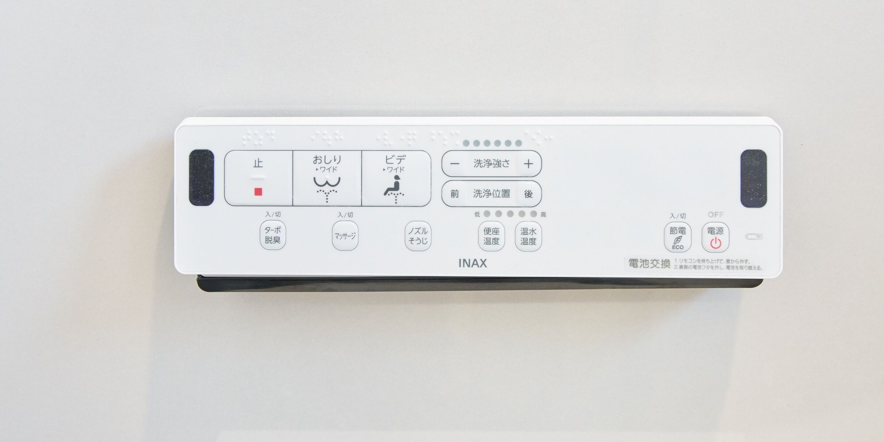A control panel with various buttons and indicators, including a red button, a water icon, and a power symbol.
