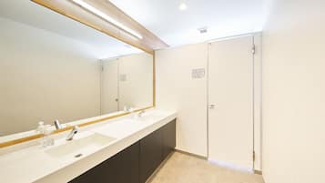 A modern bathroom with a long vanity, two sinks, and a large mirror.