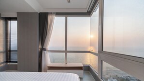 A modern hotel room with a large window, a bed, and a small bedside table. - Veranda Residence by SEA U PATTAYA (Pattaya)