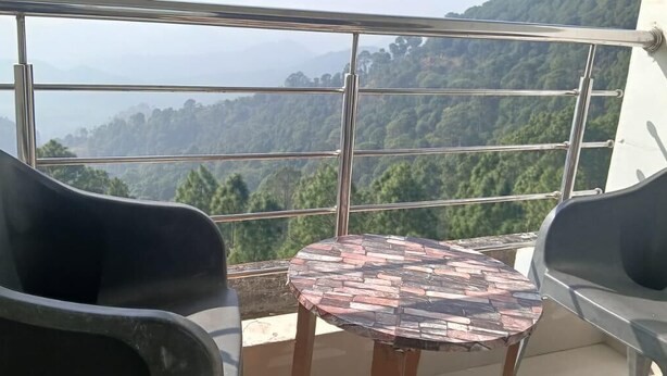 A balcony with a table and two chairs, overlooking a mountainous landscape. - Nature Hike (Lansdowne)