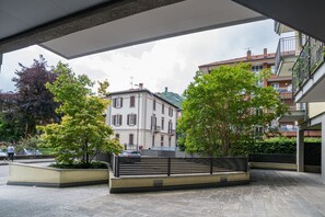 Un espacio al aire libre con un sendero pavimentado, bancos y un edificio al fondo.