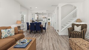 A spacious living room with a dining area, a staircase, and a kitchen in the background. - 10 min. Walk to Beach - Close to Pool - 4 Bikes (Santa Rosa Beach)