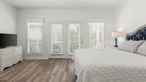 A bedroom with a bed, a dresser, a television, a ceiling fan, and a nightstand with a lamp. - 10 min. Walk to Beach - Close to Pool - 4 Bikes (Santa Rosa Beach)