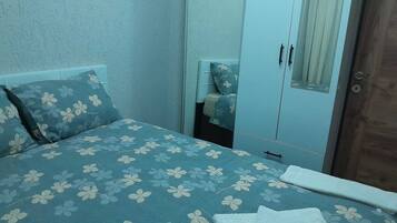 Een slaapkamer met een bed, een kledingkast en een spiegel.
