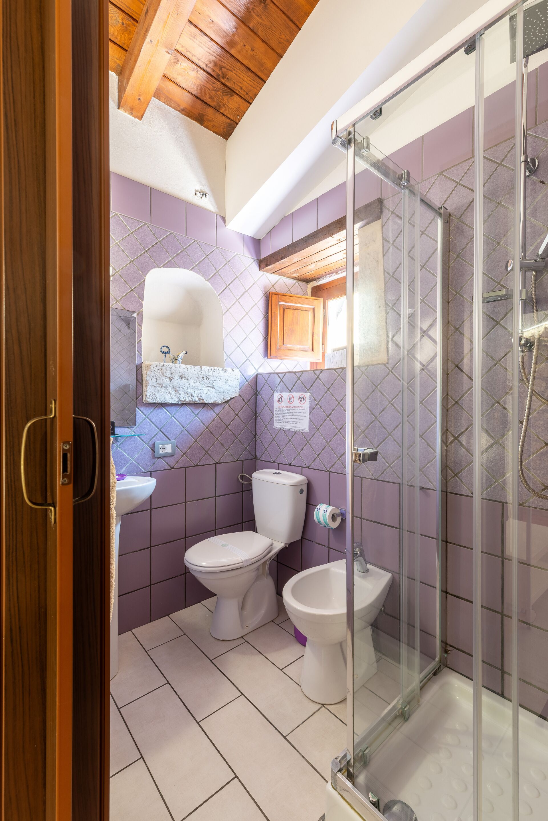 Une salle de bain équipée d’une douche, de toilettes, d’un bidet et d’un lavabo.