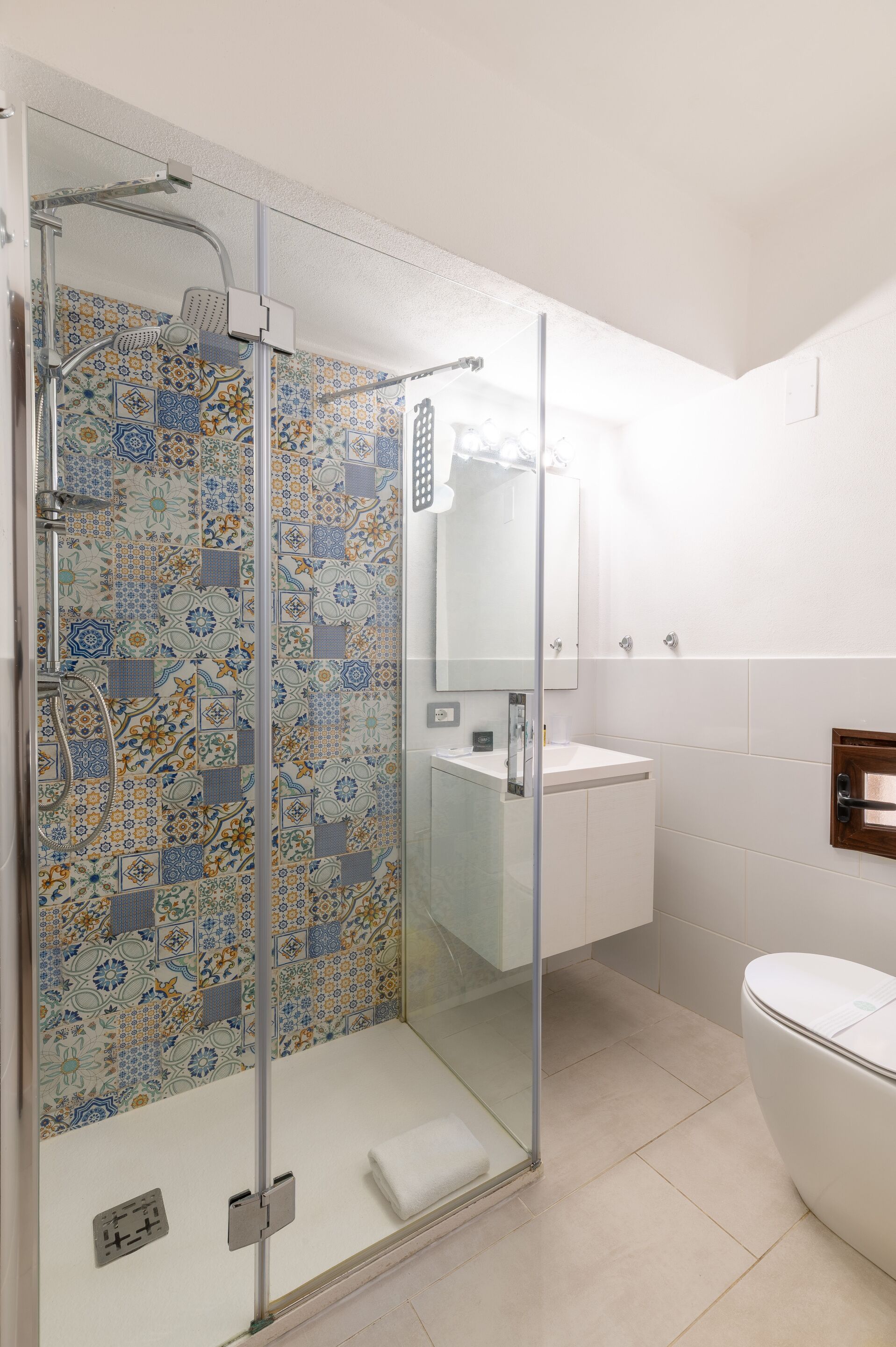 Une salle de bain moderne avec une douche à parois de verre, un lavabo blanc et des toilettes.