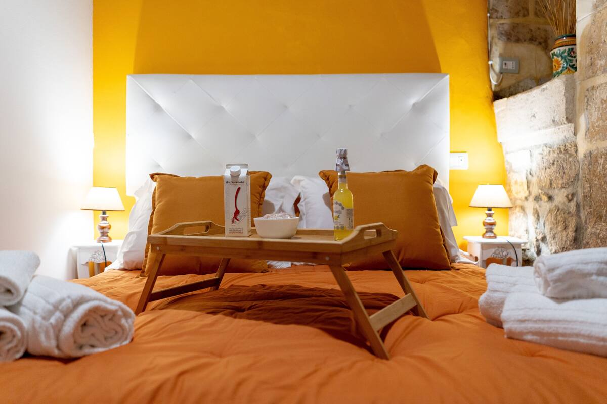 Een hotelkamer met een bed, een dienblad met ontbijtartikelen en handdoeken.