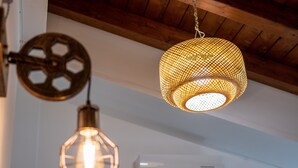 Un techo con tres lámparas colgantes, un equipo de aire acondicionado y vigas de madera.