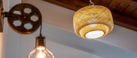 A ceiling with three hanging light fixtures, an air conditioning unit, and wooden beams.