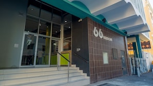 Entrada de un edificio con una escalera que conduce a una puerta con el número 6.