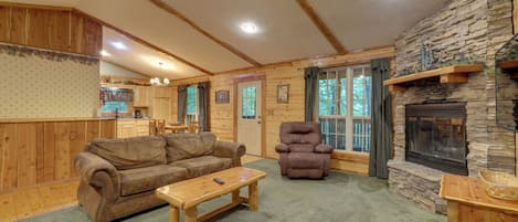 Ein gemütliches Blockhaus-Interieur mit Kamin, Holzmöbeln und einer Wand aus Naturstein.